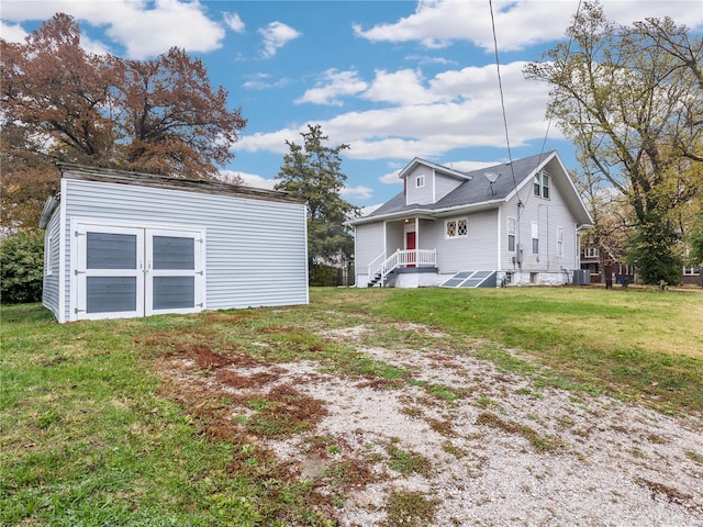 back of property featuring a yard, a shed, and central AC