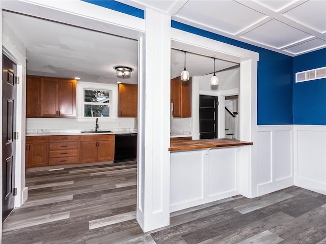 kitchen with dishwasher, sink, dark hardwood / wood-style floors, decorative light fixtures, and butcher block counters