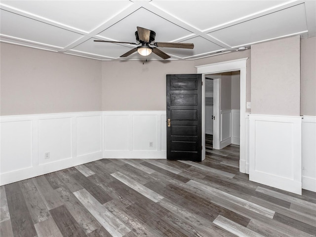 empty room with ceiling fan, dark wood-type flooring, and coffered ceiling