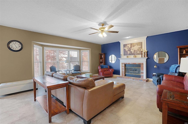 living room with a fireplace, ceiling fan, and a textured ceiling