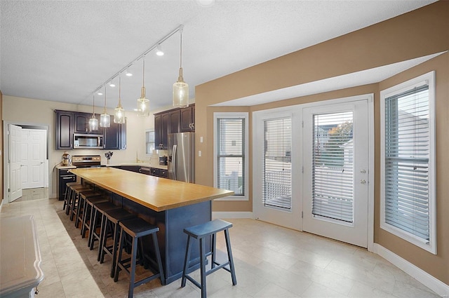 kitchen featuring a breakfast bar area, dark brown cabinets, a kitchen island, and appliances with stainless steel finishes