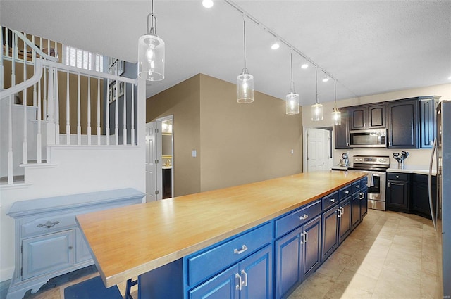 kitchen featuring blue cabinetry, wood counters, a kitchen island, and stainless steel appliances