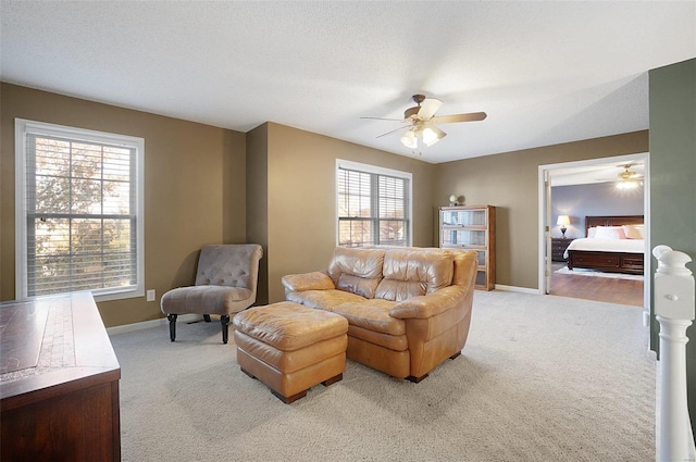 carpeted living room with ceiling fan and a textured ceiling