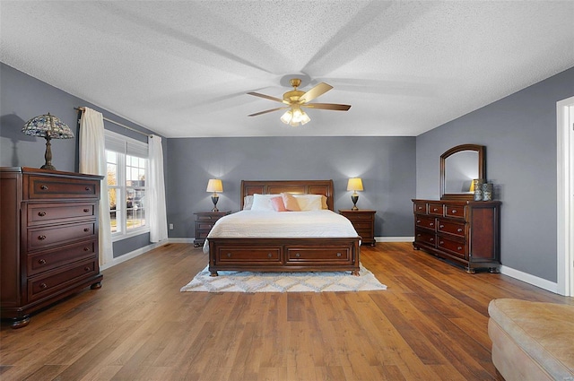 bedroom featuring ceiling fan, a textured ceiling, and hardwood / wood-style flooring