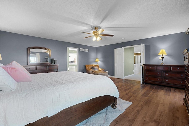 bedroom with a textured ceiling, ceiling fan, and dark wood-type flooring