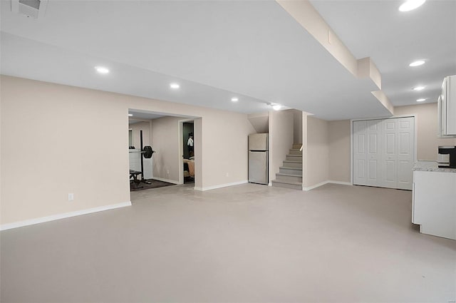 basement featuring stainless steel refrigerator