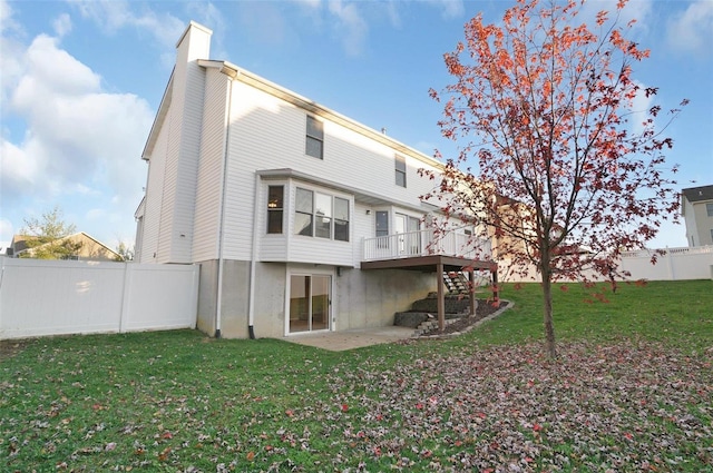 back of property with a lawn, a patio, and a deck