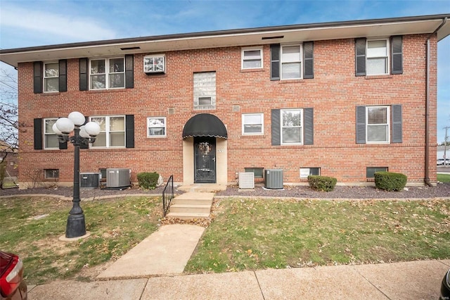 view of front of property with central air condition unit and a front yard