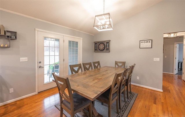 dining room featuring vaulted ceiling, light hardwood / wood-style flooring, and crown molding