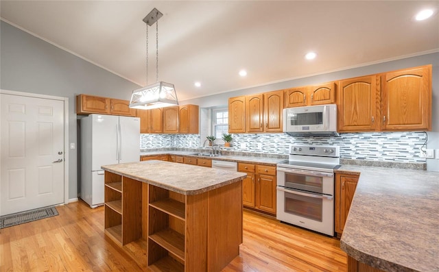 kitchen featuring white appliances, light hardwood / wood-style floors, a kitchen island, and hanging light fixtures