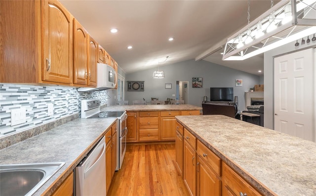 kitchen featuring backsplash, lofted ceiling with beams, decorative light fixtures, light hardwood / wood-style floors, and stainless steel appliances