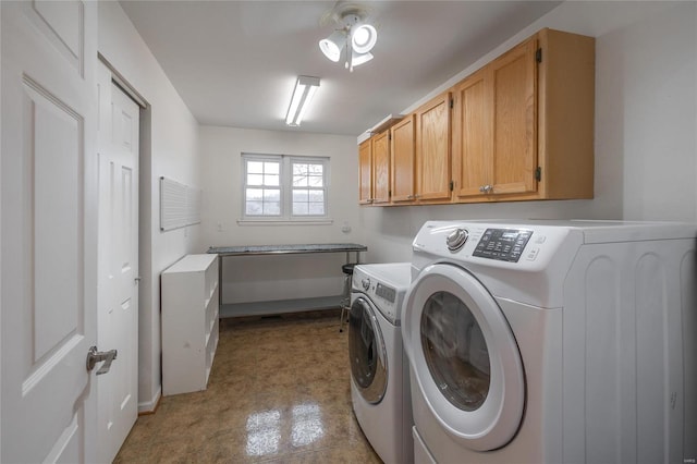 laundry area with ceiling fan, washer and clothes dryer, and cabinets