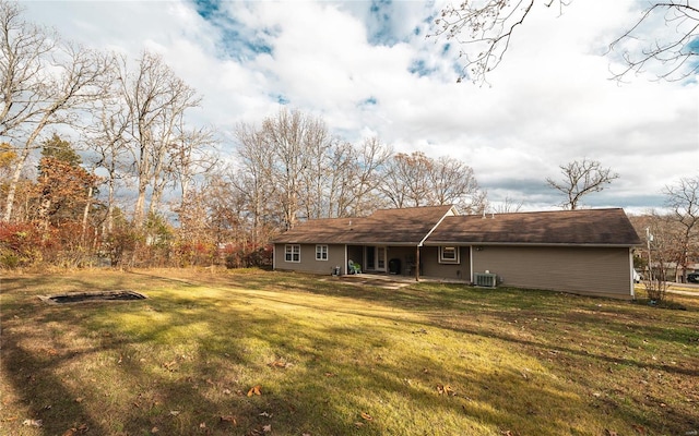 rear view of property featuring a yard and central AC