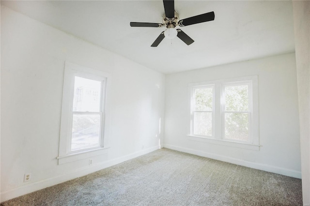 carpeted spare room featuring ceiling fan