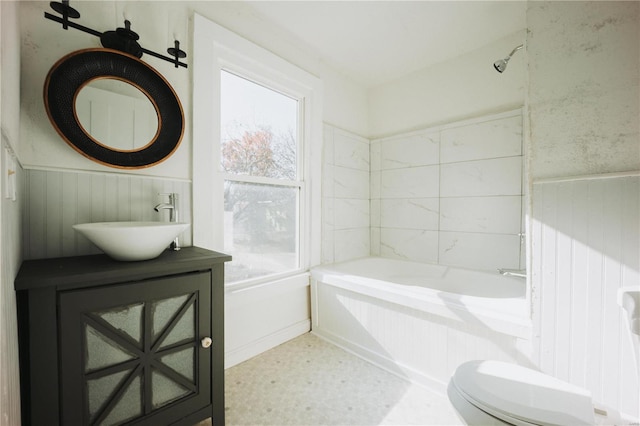 full bathroom with tiled shower / bath, vanity, and toilet