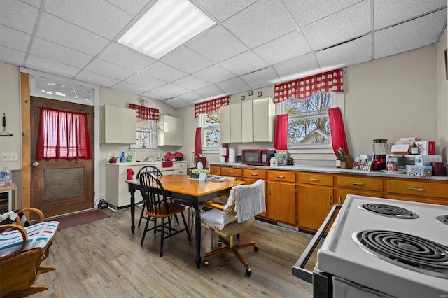 kitchen featuring white electric range, a paneled ceiling, and light hardwood / wood-style flooring