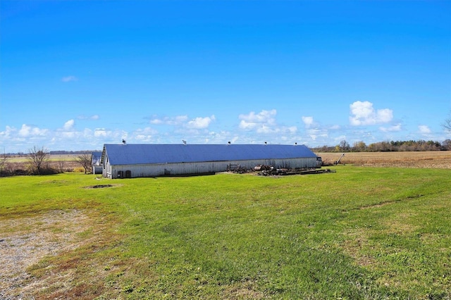 view of yard featuring a rural view and an outbuilding