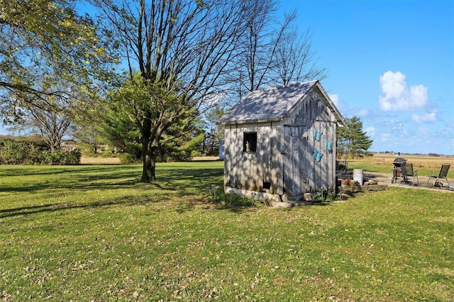 view of outbuilding featuring a yard and a rural view