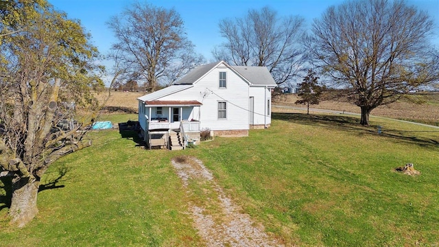 rear view of property with a porch and a yard