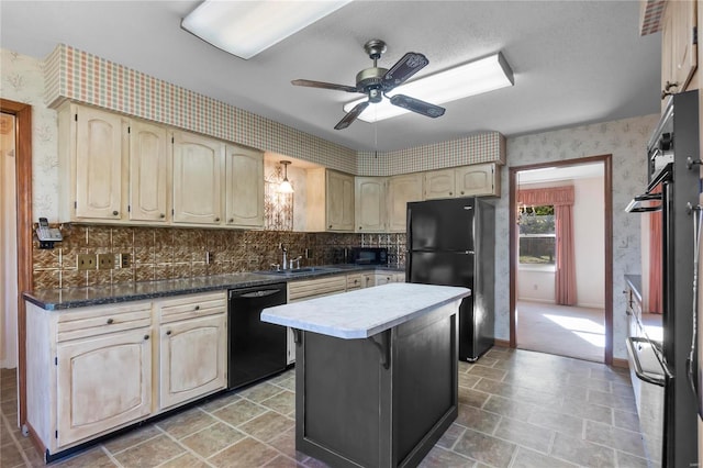 kitchen with ceiling fan, sink, cream cabinets, a kitchen island, and black appliances