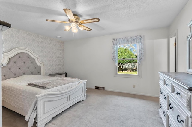 carpeted bedroom with a textured ceiling and ceiling fan