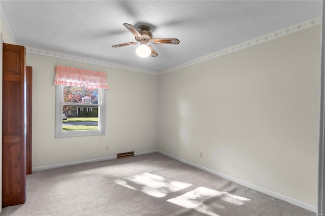 spare room with light carpet, ceiling fan, and a textured ceiling