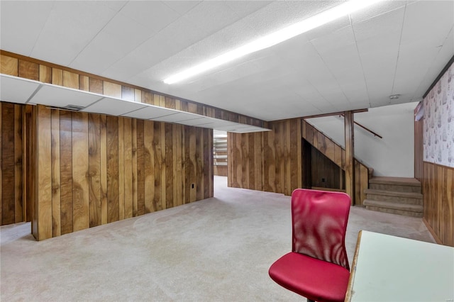 basement featuring light colored carpet and wooden walls