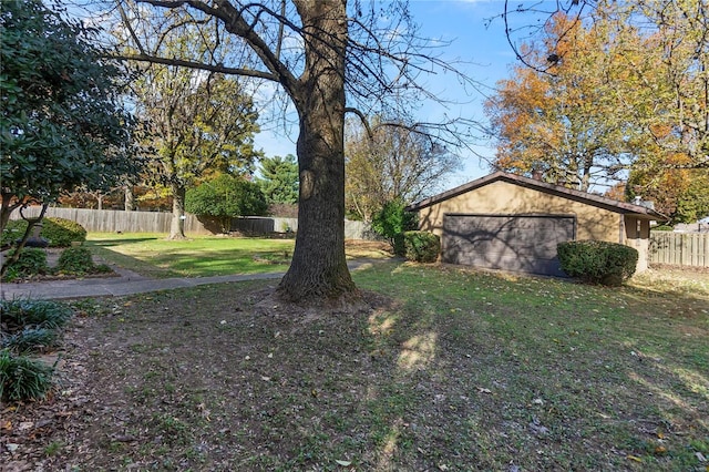 view of yard with a garage and an outbuilding