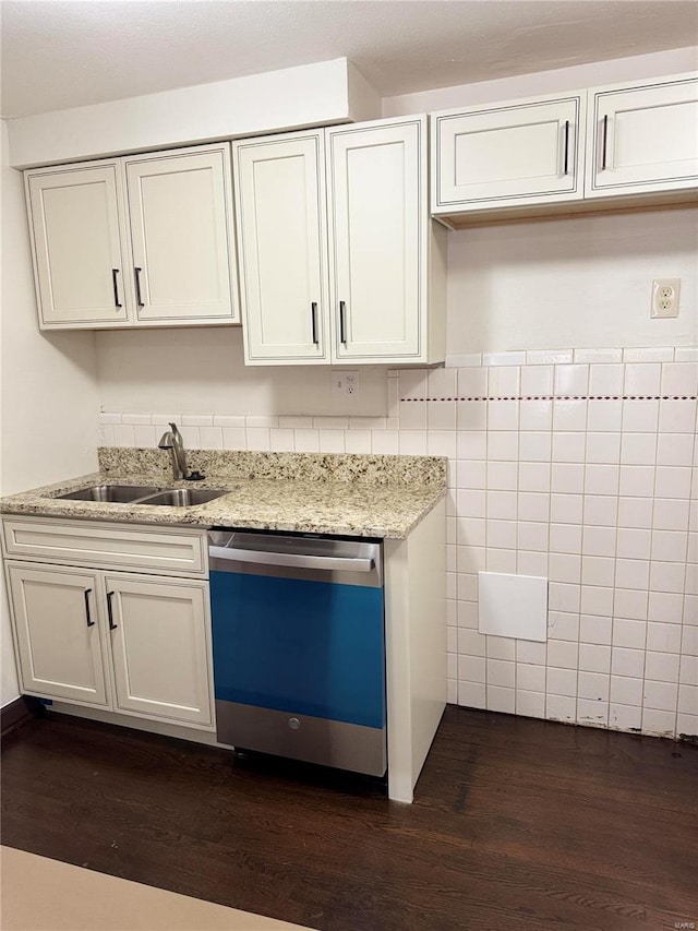 kitchen featuring dishwasher, dark wood-type flooring, sink, light stone countertops, and tile walls