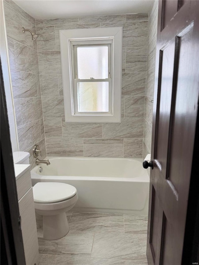 full bathroom with vanity, tiled shower / bath combo, and toilet