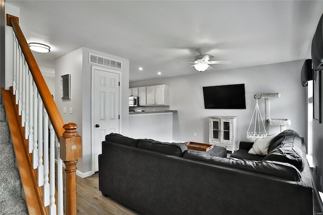 living room featuring wood-type flooring and ceiling fan