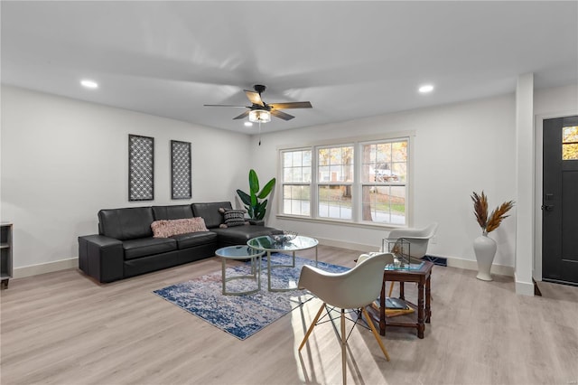 living room featuring light hardwood / wood-style floors and ceiling fan