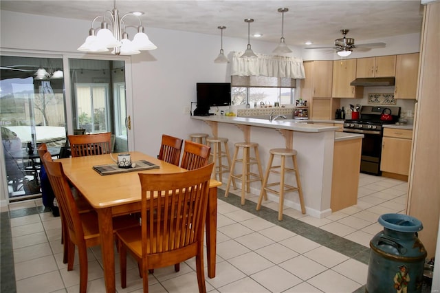 dining area featuring ceiling fan with notable chandelier and light tile patterned floors