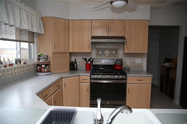 kitchen featuring light brown cabinets, stainless steel range with gas cooktop, ceiling fan, light tile patterned floors, and tasteful backsplash