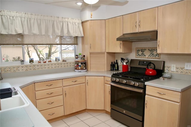 kitchen featuring backsplash, stainless steel range with gas cooktop, light brown cabinets, and light tile patterned floors