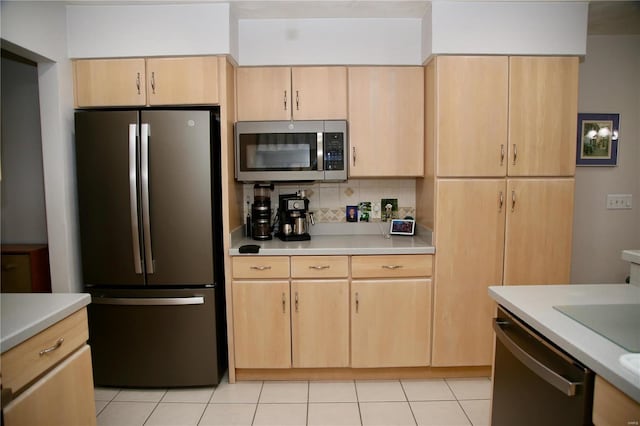 kitchen featuring decorative backsplash, light brown cabinetry, light tile patterned floors, and appliances with stainless steel finishes