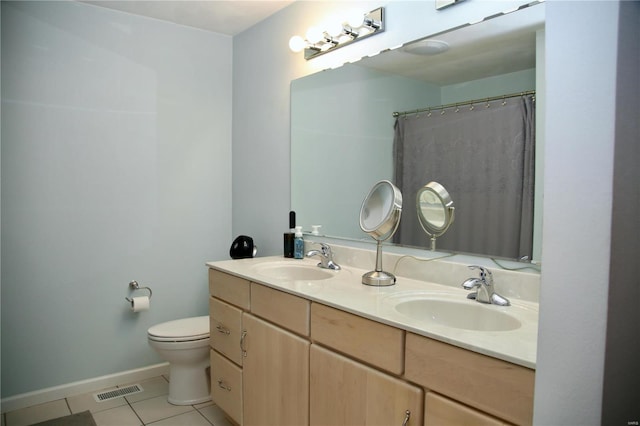 bathroom featuring tile patterned flooring, vanity, toilet, and walk in shower