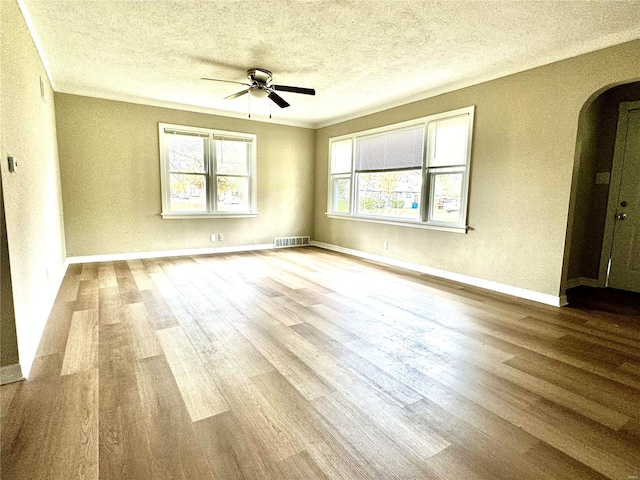 unfurnished room with ceiling fan, light hardwood / wood-style floors, and a textured ceiling