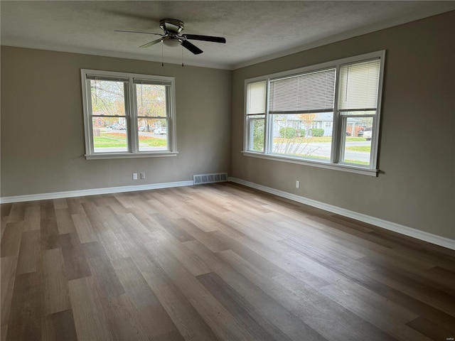 unfurnished room featuring a textured ceiling, light hardwood / wood-style flooring, ceiling fan, and ornamental molding