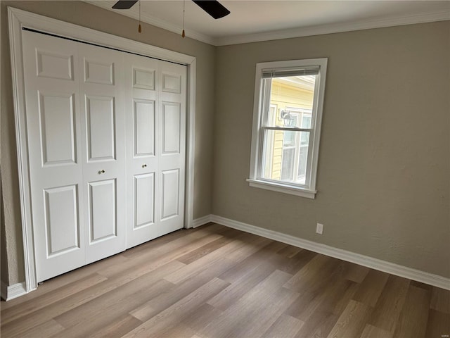 unfurnished bedroom with light hardwood / wood-style flooring, a closet, ornamental molding, and ceiling fan