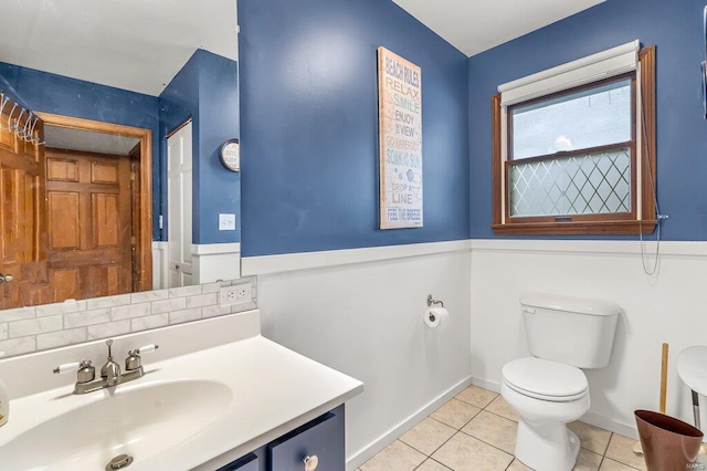 bathroom featuring toilet, tile patterned flooring, baseboards, and vanity