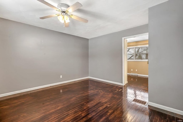 empty room with ceiling fan, wood-type flooring, visible vents, and baseboards