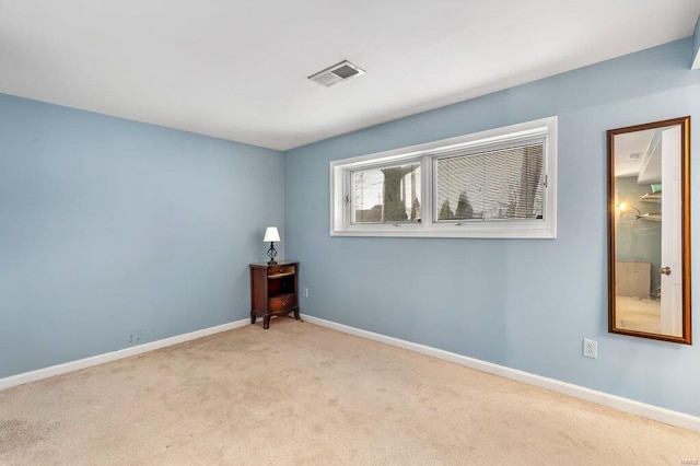 carpeted empty room featuring visible vents and baseboards