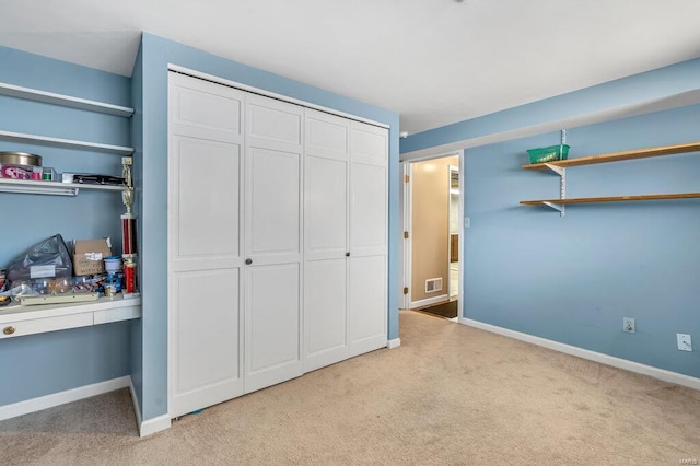 bedroom with light carpet, visible vents, baseboards, and a closet