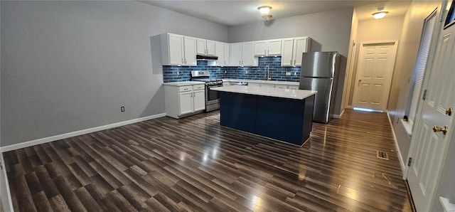 kitchen featuring white cabinets, stainless steel appliances, a kitchen island, and dark wood-type flooring