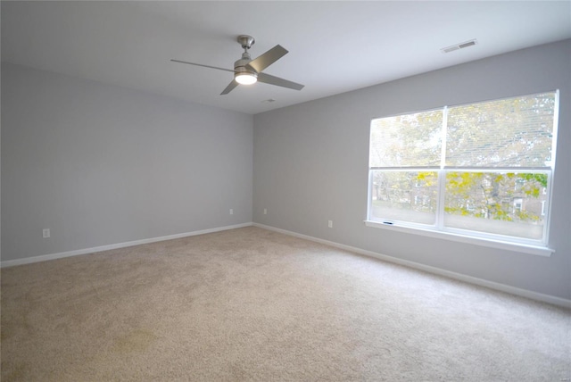 carpeted spare room with ceiling fan