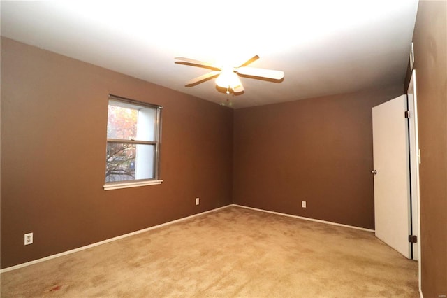 spare room featuring light carpet and ceiling fan