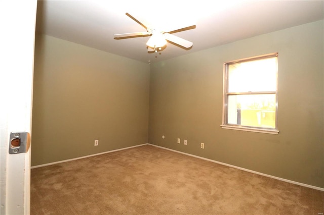 carpeted spare room with ceiling fan