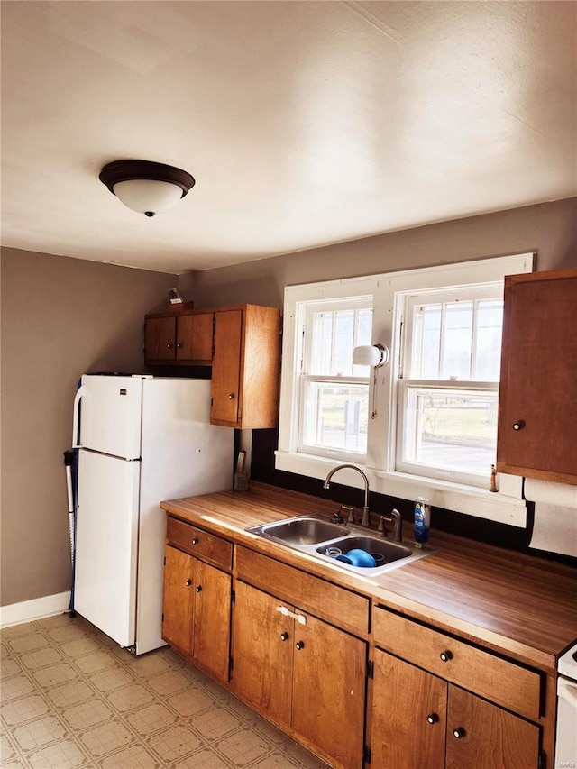 kitchen featuring white fridge and sink