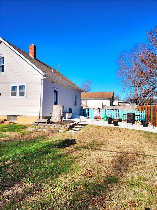 rear view of property with a yard and a patio